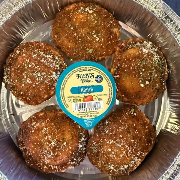 Five fried ravioli with parmesan and herbs, and a cup of Ken's Ranch dressing in a foil container.